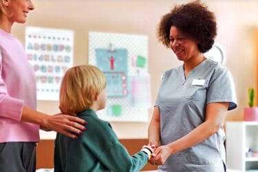 Healthcare professional greeting a child and parent during a supportive therapy visit